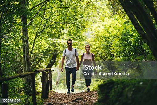 istock Couple hike along forested trail in the morning 1292251292