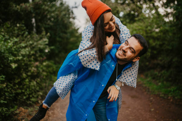 Couple hikes in the forest in rainy weather stock photo