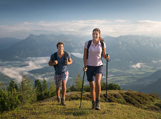 Couple hiking, Austrian Alps Couple hiking in the Austrian Alps at sunrise. Nikon D800e. Converted from RAW. ausseerland stock pictures, royalty-free photos & images
