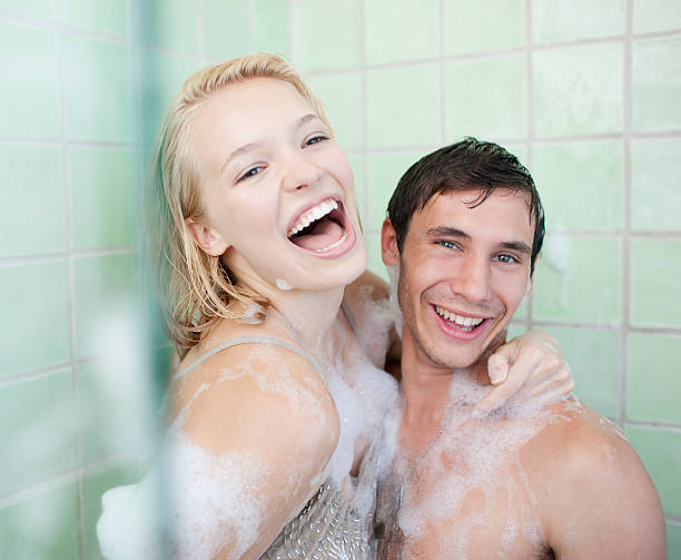 пара в ванной покрыт мыло suds - women in bathroom together стоковые фото и...