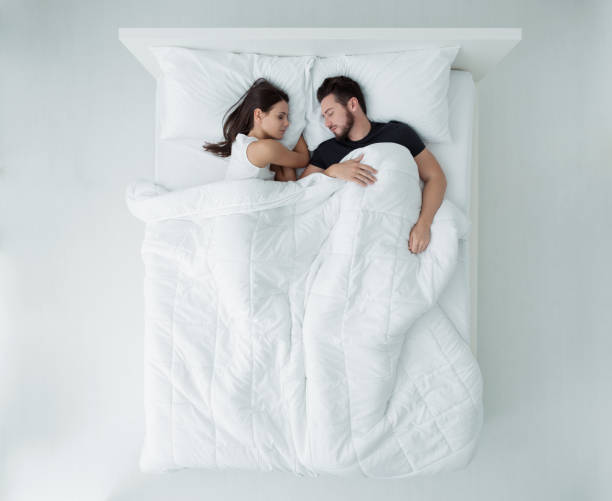 Couple in bed Loving couple relaxing and sleeping in bed, top view man sleeping in bed top view stock pictures, royalty-free photos & images