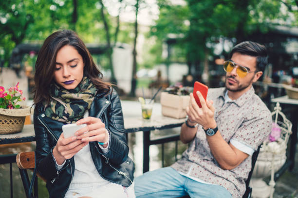 par i café använder smartphones och talar inte - boring date bildbanksfoton och bilder