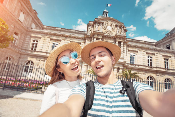 een paar verliefd op een europese man en een aziatisch meisje dat selfie-foto neemt in de luxemburgse tuin in parijs - castle couple stockfoto's en -beelden