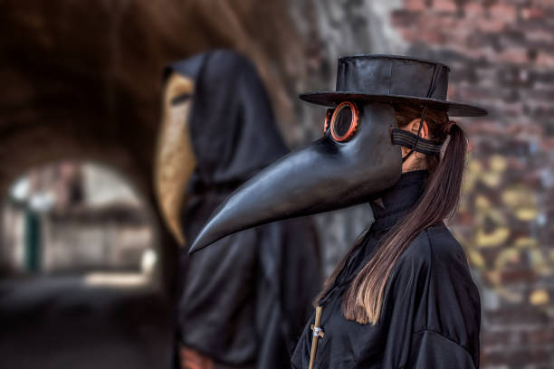 Couple in love in suits and masks of plague doctor during epidemic A couple in love in costumes and masks of a plague doctor during an epidemic bubonic plague photos stock pictures, royalty-free photos & images