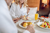 istock A couple in white robes having breakfast and looking pleased 1327285909