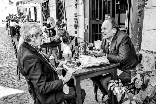 A couple of friends enjoy life in a picturesque tavern in the Monti district of Rome stock photo