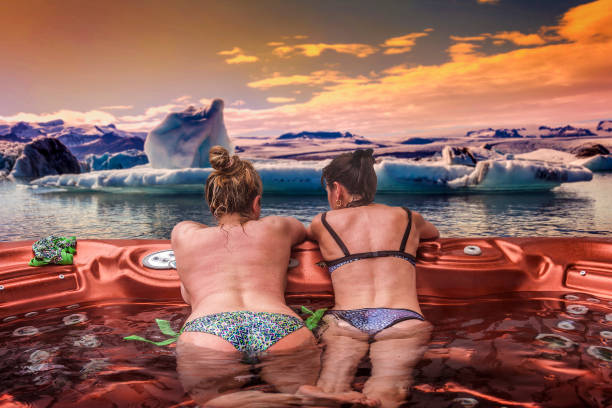 par av damer som njuter av fördelarna med bubbelpoolen - ice bath ocean bildbanksfoton och bilder