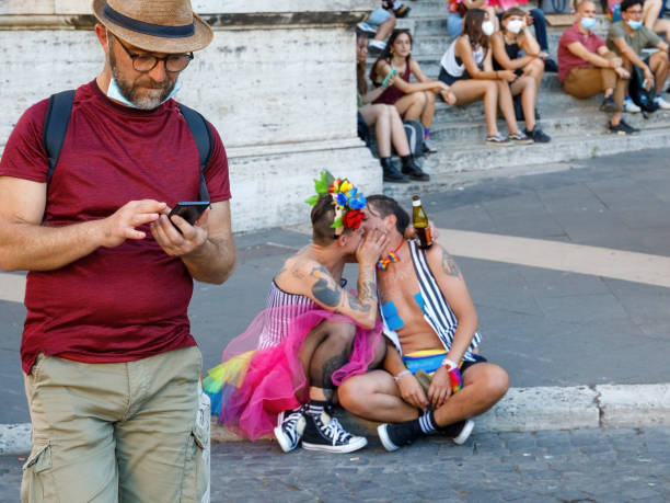 A couple of protesters kiss in the street during the Rome gay pride. stock photo