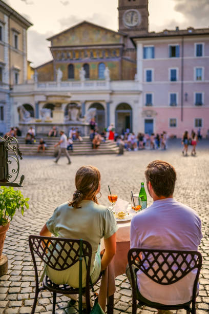 a couple of tourists admires the artistic beauties of santa maria in trastevere in the heart of rome - focus un focus stockfoto's en -beelden
