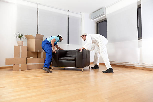 Couple of workers moving the furniture into a new house stock photo