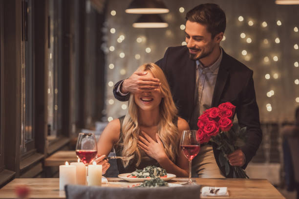 A man surprising his girlfriend with romantic dinner date https://www.istockphoto.com/photos/dinner-date