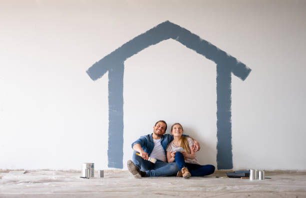 Couple painting their house and daydreaming about how itâs going to look stock photo