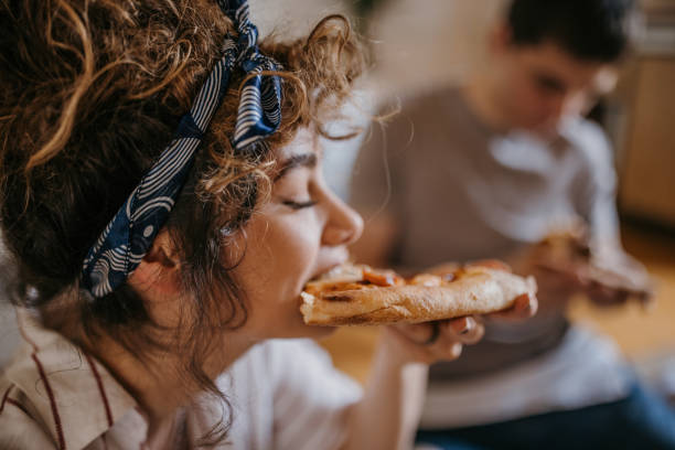 Couple playing eating pizza at home stock photo
