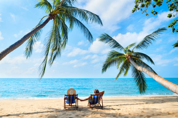 Couple relax on the beach enjoying beautiful sea on the tropical island Couple relax on the beach enjoying beautiful sea on the tropical island. Summer beach vacation concept beach holiday stock pictures, royalty-free photos & images