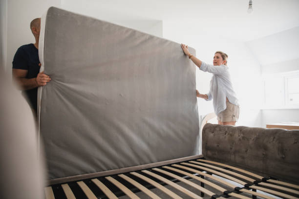 Couple Setting Up Bed Together in New Home stock photo