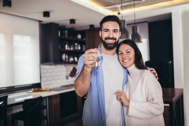 Couple showing keys to new home stock photo
