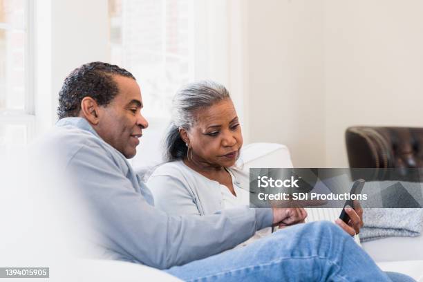 Couple sits on the couch reading an article