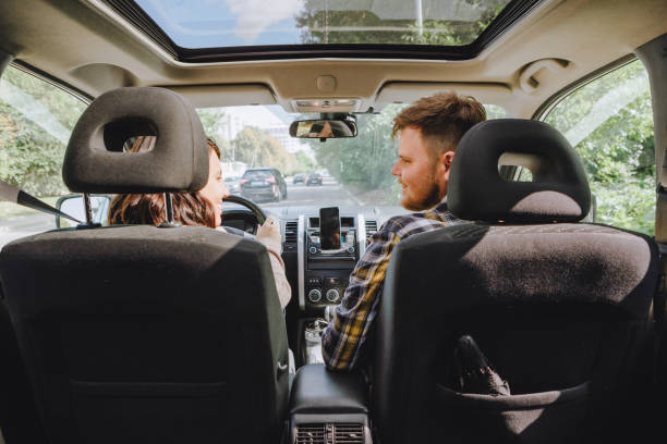 couple sitting in car driving to travel destination stock photo