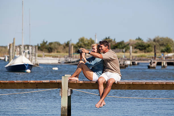 Couple sitting on a dock  50 59 years stock pictures, royalty-free photos & images