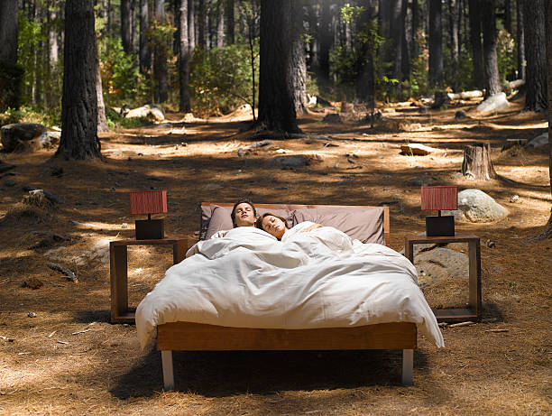 um casal dormir em uma cama ao ar livre na floresta - sleeping couple imagens e fotografias de stock