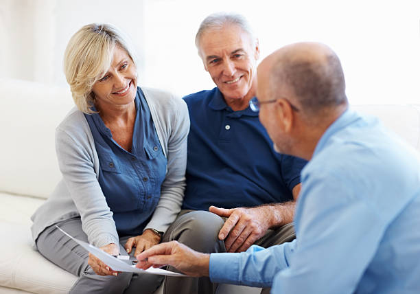 Couple smiling and listening to financial planner stock photo