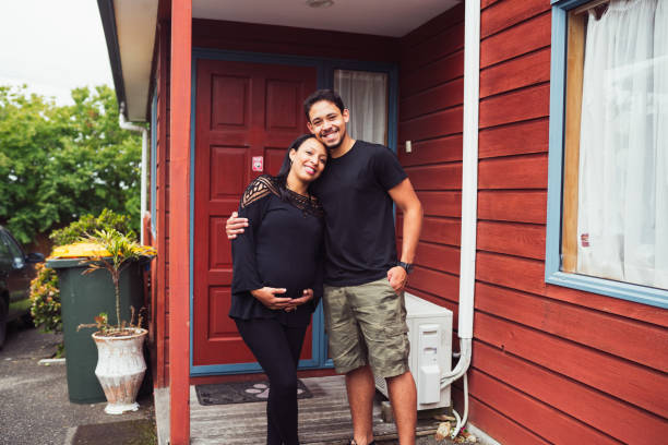 paar glimlachend voor hun huis. - pregnant couple outside stockfoto's en -beelden