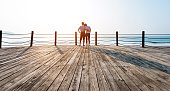 Couple standing on boardwalk at the beach.