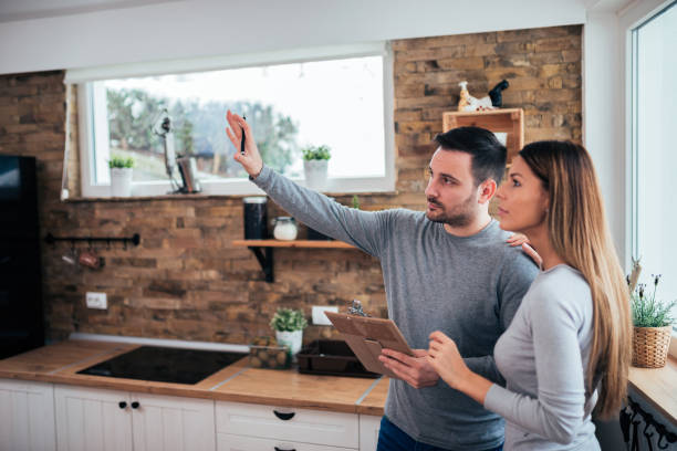 Couple talking about home renovation. Standing in the kitchen and discussing apartment renovation ideas. Couple talking about home renovation. Standing in the kitchen and discussing apartment renovation ideas. renovation stock pictures, royalty-free photos & images