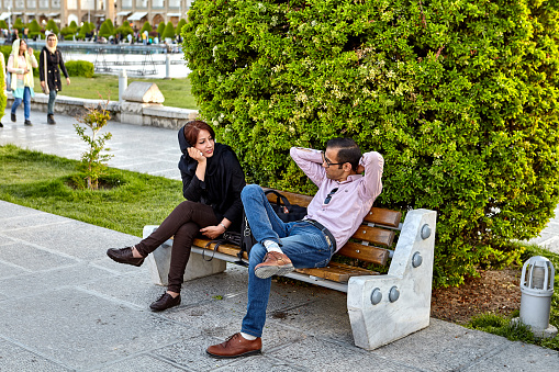 Foto de Casal Conversando Sentado No Banco Na Praça Naghshe Jahan Irã e  mais fotos de stock de Irã - iStock