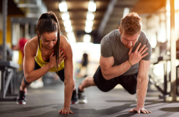Couple training together Couple training together in fitness center manufactured object stock pictures, royalty-free photos & images