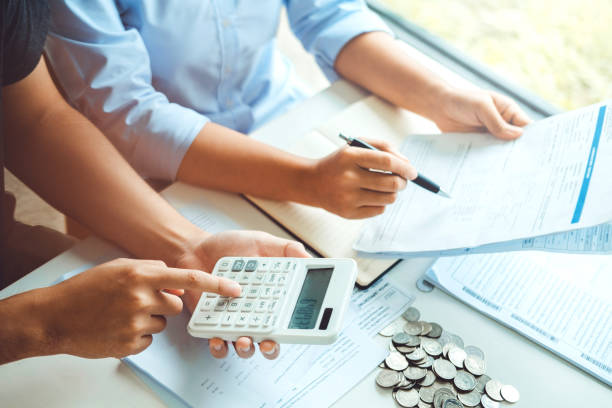 Couple using calculator Accounting Calculating Cost Economic bills with money stack step growing growth saving money in home , finance concept stock photo