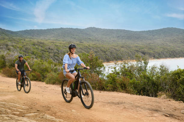 Couple using e-bike in Tuscany, Italy Couple using e-bike (electric bicycle) in Tuscany, Italy electric bike workout stock pictures, royalty-free photos & images