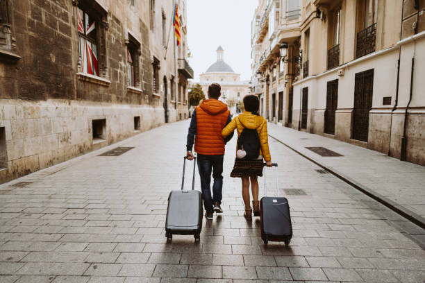 Couple visiting Valencia Rear view of couple arriving in Valencia early in the morning travel destinations stock pictures, royalty-free photos & images