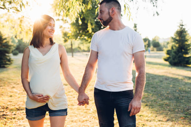 paar dat en handen loopt houdt - pregnant couple outside stockfoto's en -beelden