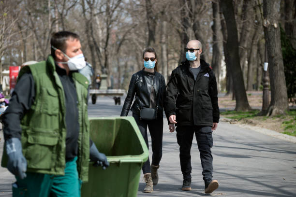 Couple walking in the park and wearing face mask to protect from corona virus.  COVID- 19 pandemic stock photo