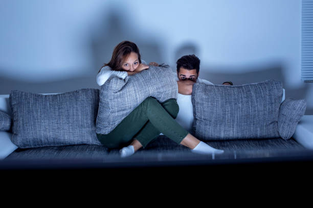 Couple watching a horror movie stock photo