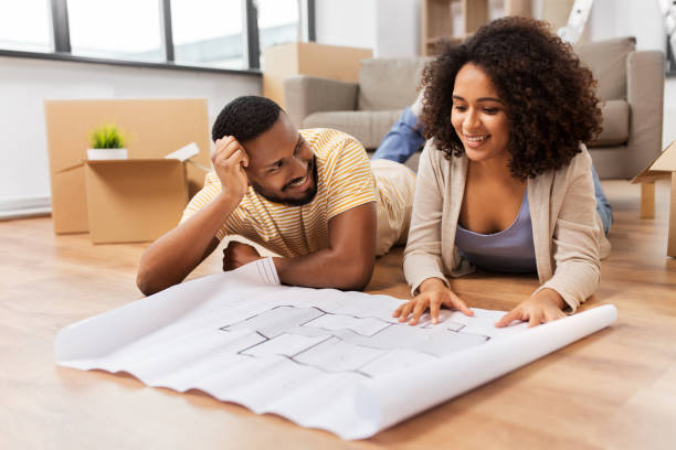 couple with boxes and blueprint moving to new home stock photo