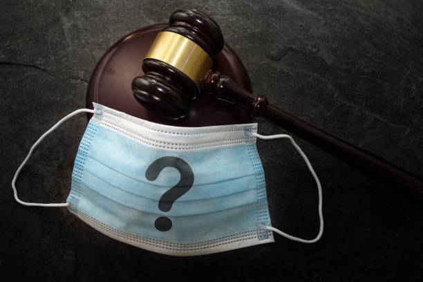 Court legal gavel and facemask with question mark -- Coronavirus mask mandate concept stock photo