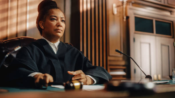 Court of Law Trial in Session: Portrait of Honorable Female Judge Reading Decision. Presiding Justice Pronouncing Sentence. Not Guilty Verdict Judgment. stock photo