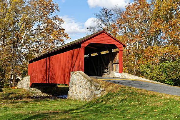 Covered Bridge in Autumn Pool Forge covered bridge in Fall, Lancaster County, Pennsylvania, USA. covered bridge stock pictures, royalty-free photos & images