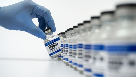 Covid-19 Corona Virus 2019-ncov vaccine vials medicine drug bottles syringe injection blue nitrile surgical gloves. Vaccination, immunization, treatment to cure Covid 19 Corona Virus infection Concept