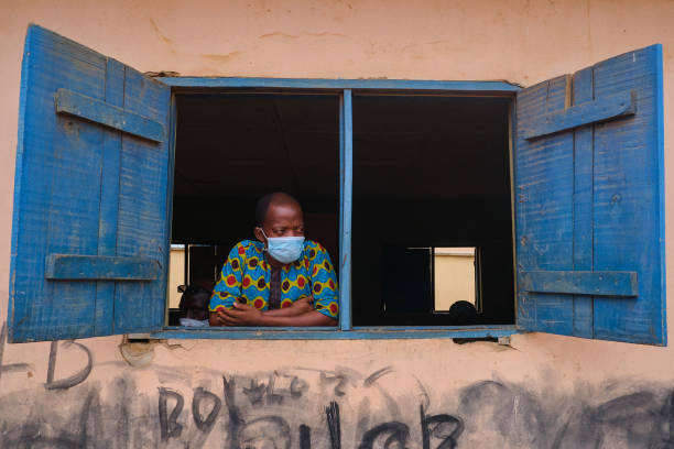 Covid-19 Social Distancing Advocacy A man looks out the window at a venue for the Lagos State Environmental Protection Agency (LASEPA) and the Lagos State Safety Commission Social Distancing Advocacy program at Ikorodu, Lagos. nigeria stock pictures, royalty-free photos & images