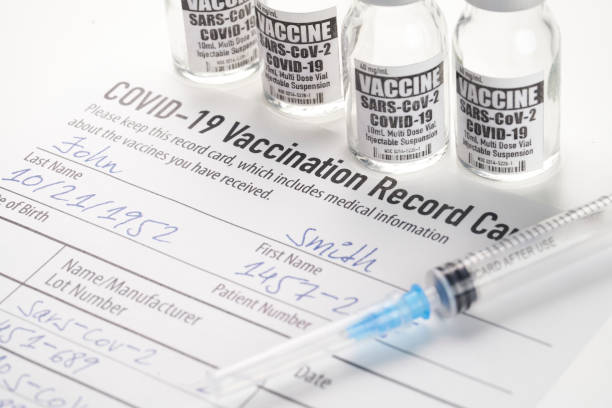 Covid-19 vaccination record card with syringe and vial Covid-19 vaccination record card with syringe and vial cdc vaccine card stock pictures, royalty-free photos & images