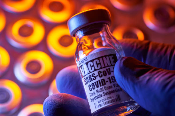 szczepionka covid-19 - fiolki medyczne: trzymanie za rękę, zbliżenie i kolorowe - covid vaccine zdjęcia i obrazy z banku zdjęć