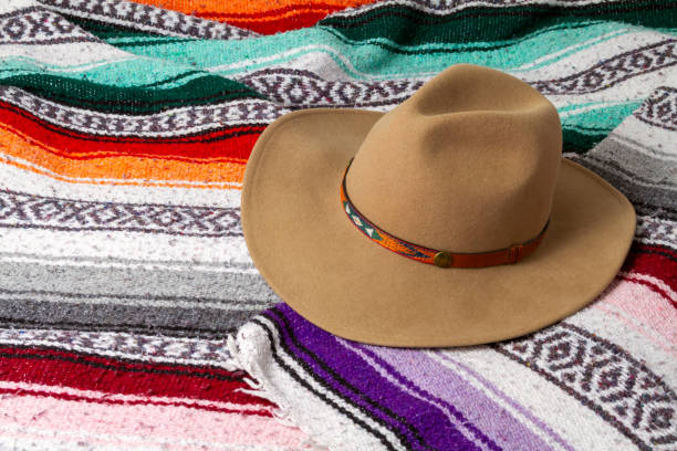 A cowboy hat on a colorful Southwestern design blanket in the background stock photo