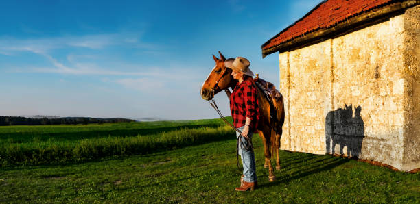 Cowgirl with her horse Cowgirl genießt die Zeit mit ihrem liebstem im Sonnenuntergang auf einer Wiese vor der Kapelle pferd stock pictures, royalty-free photos & images
