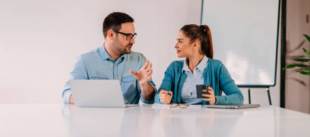 Coworkers discussing in the office stock photo