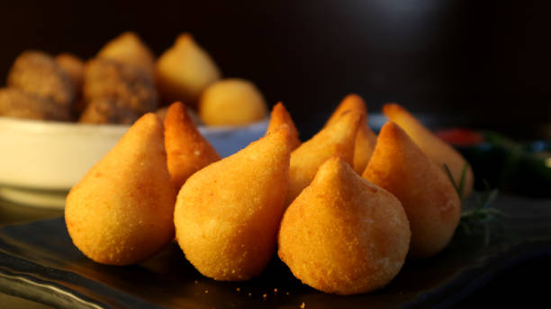 Coxinhas Brazilian snack stuffed with chicken on dark background. Traditional party food. stock photo