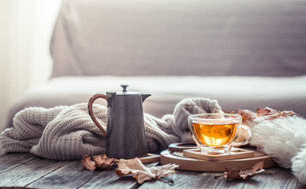 Cozy autumn still life with a cup of tea Cozy autumn still life with a cup of tea and decor items in the living room. Home comfort concept hygge stock pictures, royalty-free photos & images