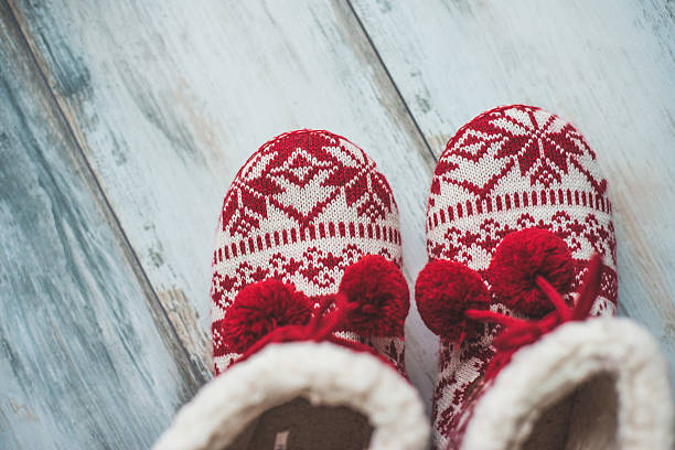 Cozy Christmas slippers on vintage wooden floor stock photo